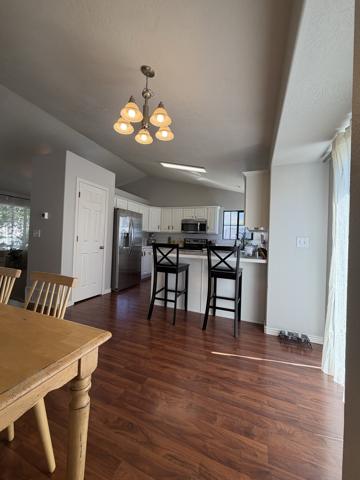 Kitchen before recessed can lighting, lit only by a single chandelier